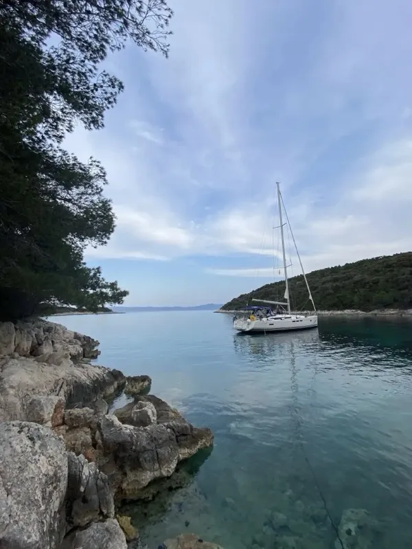 Jedrilica usidrena u uvali pored zelenog ostrva